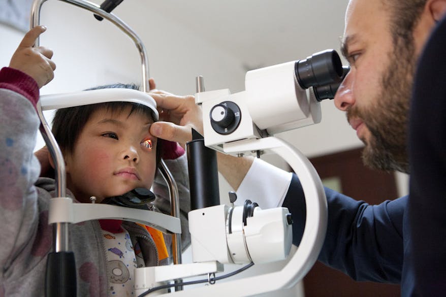 Chinese paediatric glaucoma patient Shunwen receiving an eye scan from a doctor