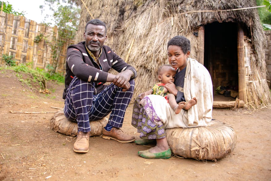 Integrated Eye Care Worker Abiyot sits with trachoma patient Malate outside her home