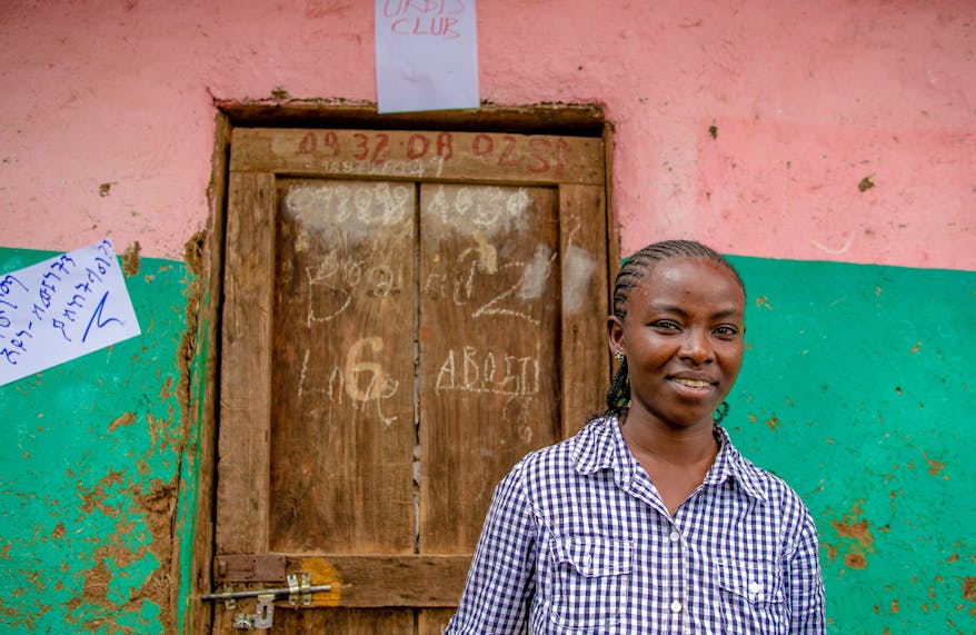 Ethiopian schoolteacher Banchi standing by a door