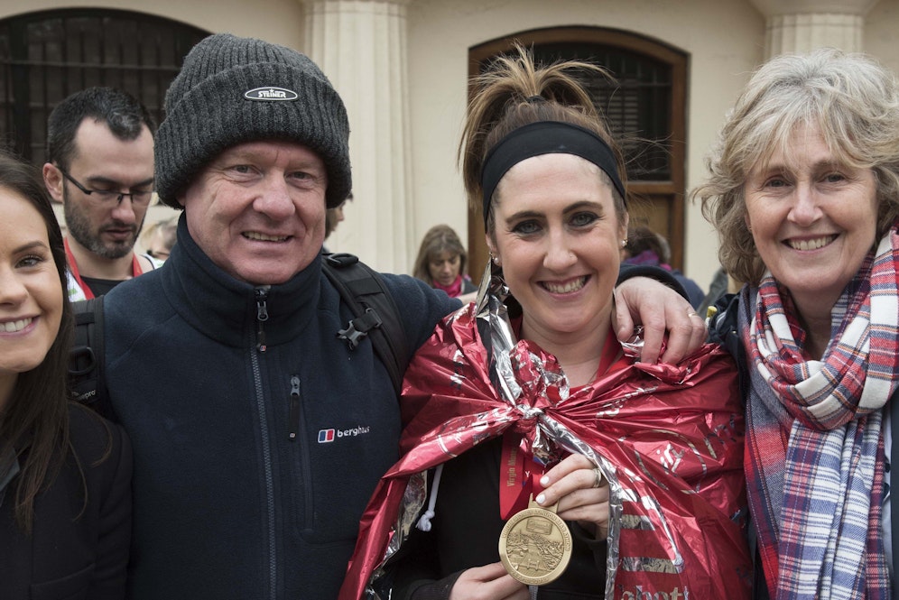 A London Marathon participant is comforted by her family and friends