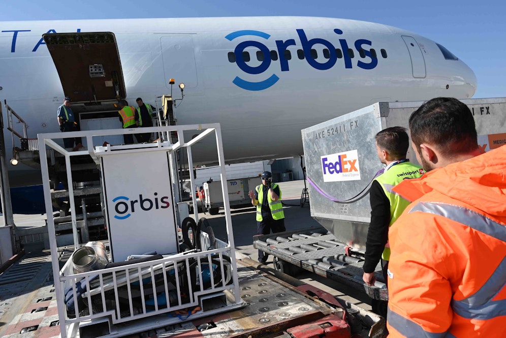 People in hi-vis clothing unpack the Orbis Flying Eye Hospital