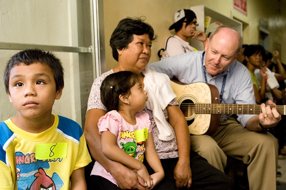 Flying Eye Hospital pilot Captain Gary Dyson calms children awaiting surgery with his impressive guitar skills