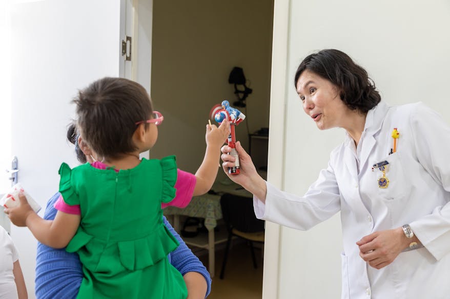 Marla plays with a toy held up by Dr. Murat