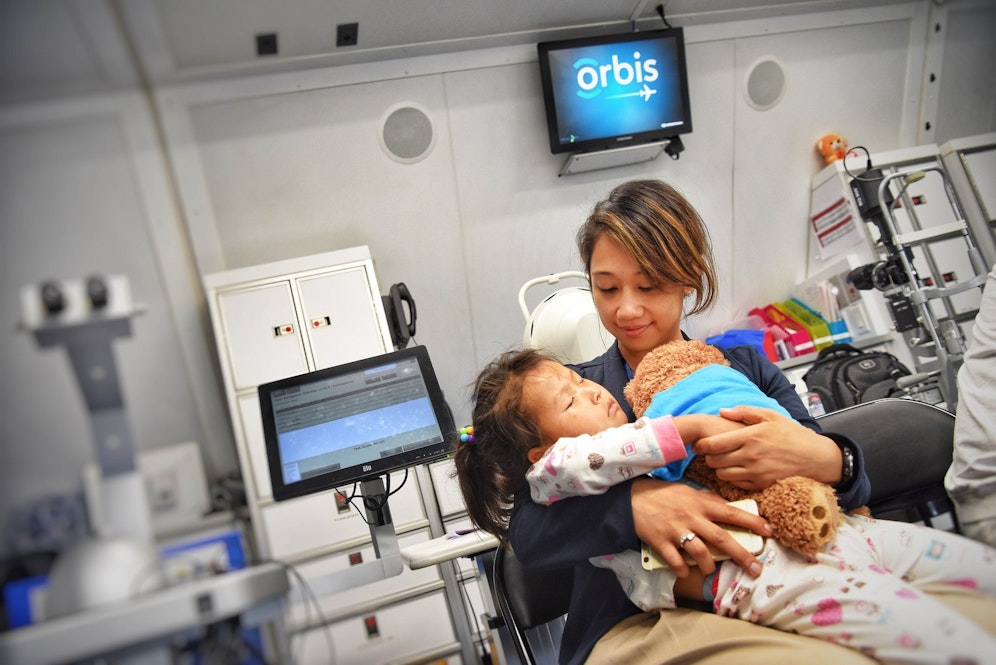 Orbis volunteer with patient on board the Flying Eye Hospital